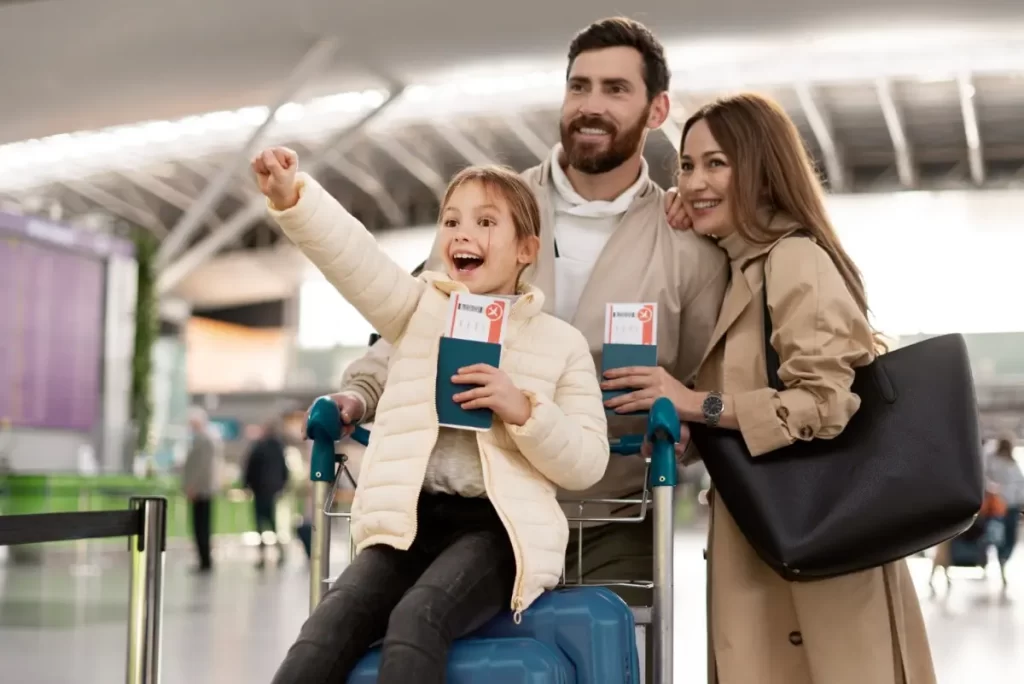 Happy family at airport preparing for travel related to Germany PR visa with passports and luggage.