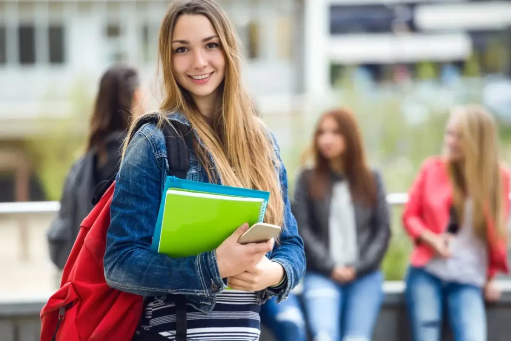 Student at German Language Institution in Cochin, Kerala holding books and smiling