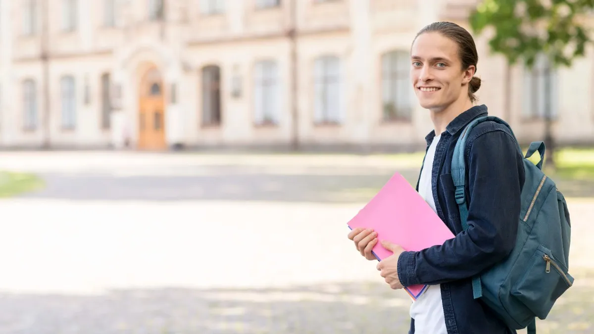 Smiling student carrying books and a backpack outside a university campus — Top German language institute in Kochi