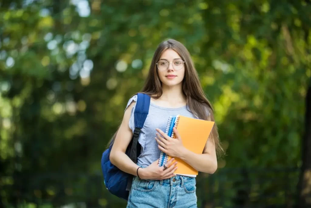 Student holding notebooks and backpack at Kerala’s No.1 German Language Institute