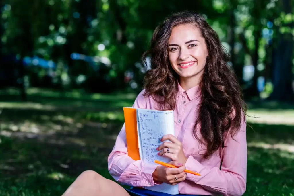 Student learning German for a German Language Certified Course in Kochi, Kerala while studying with a notebook outdoors.