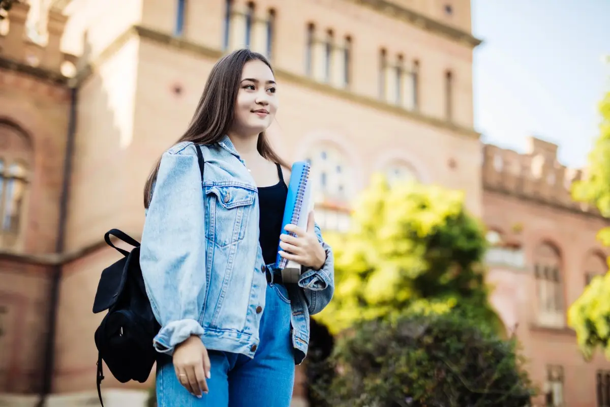 Student with books near university representing expert German language training center in Kochi, Kerala
